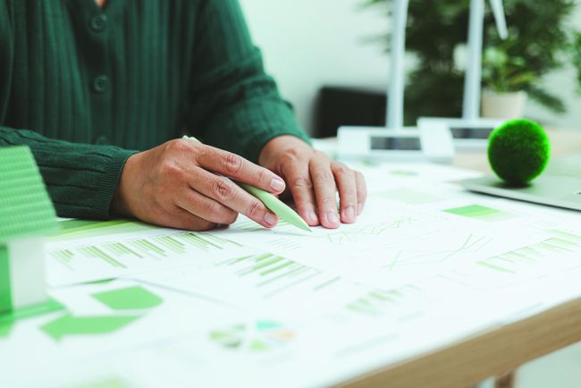 Eco-friendly,Business,Concept,With,Hand,Analyzing,Financial,Charts,And,Green